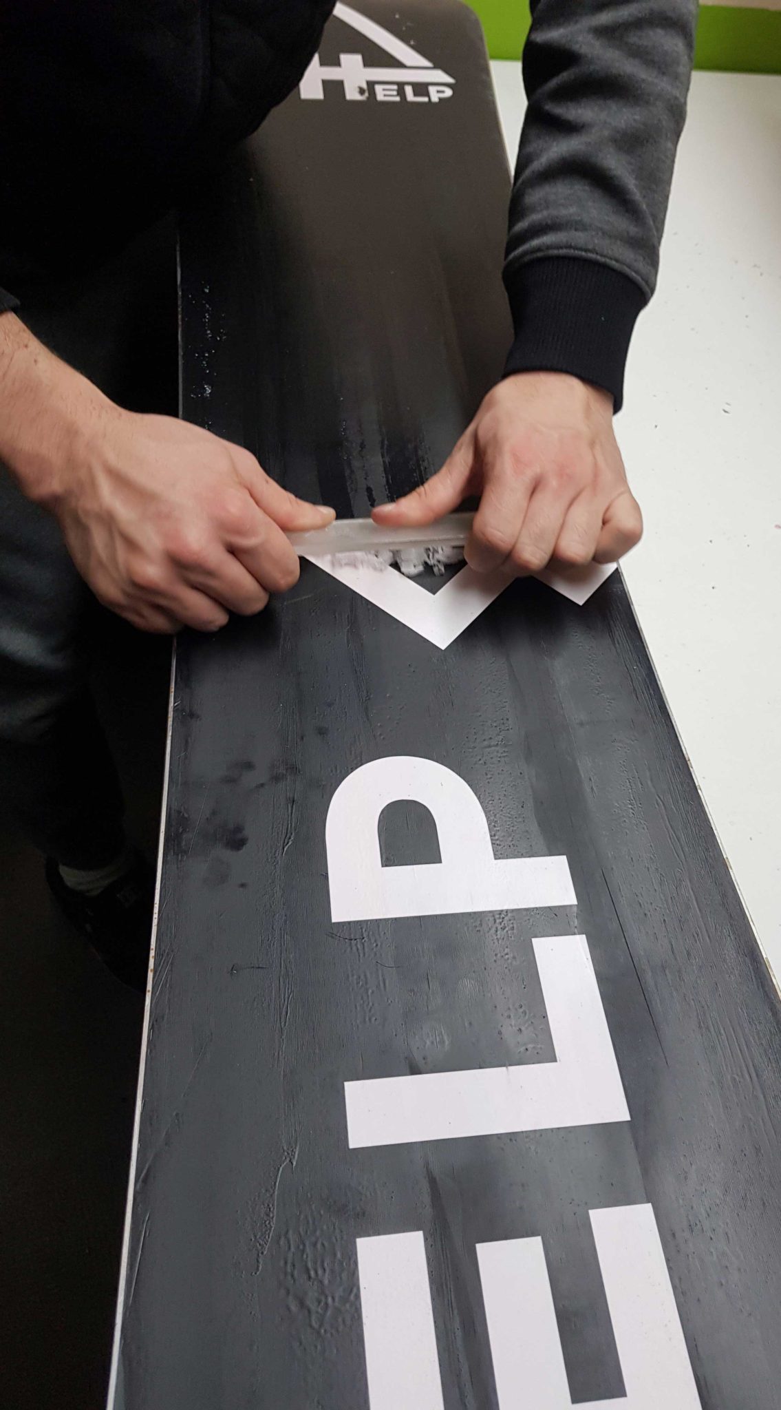 Raspando el excedente de cera de la base con un raspador plástico, de la nariz a la cola