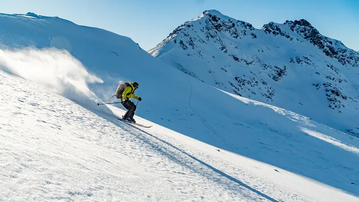 Rider throwing spray on an open slope at Cerro Catedral